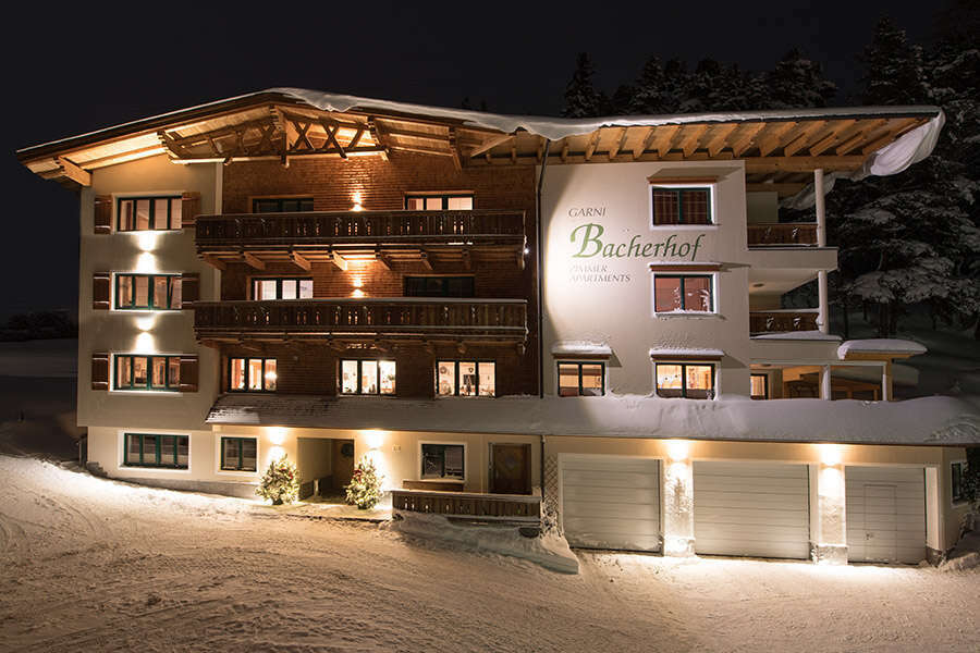 Hausansicht im Winter in der Nacht von Hotel Garni Bacherhof in St Anton am Arlberg
