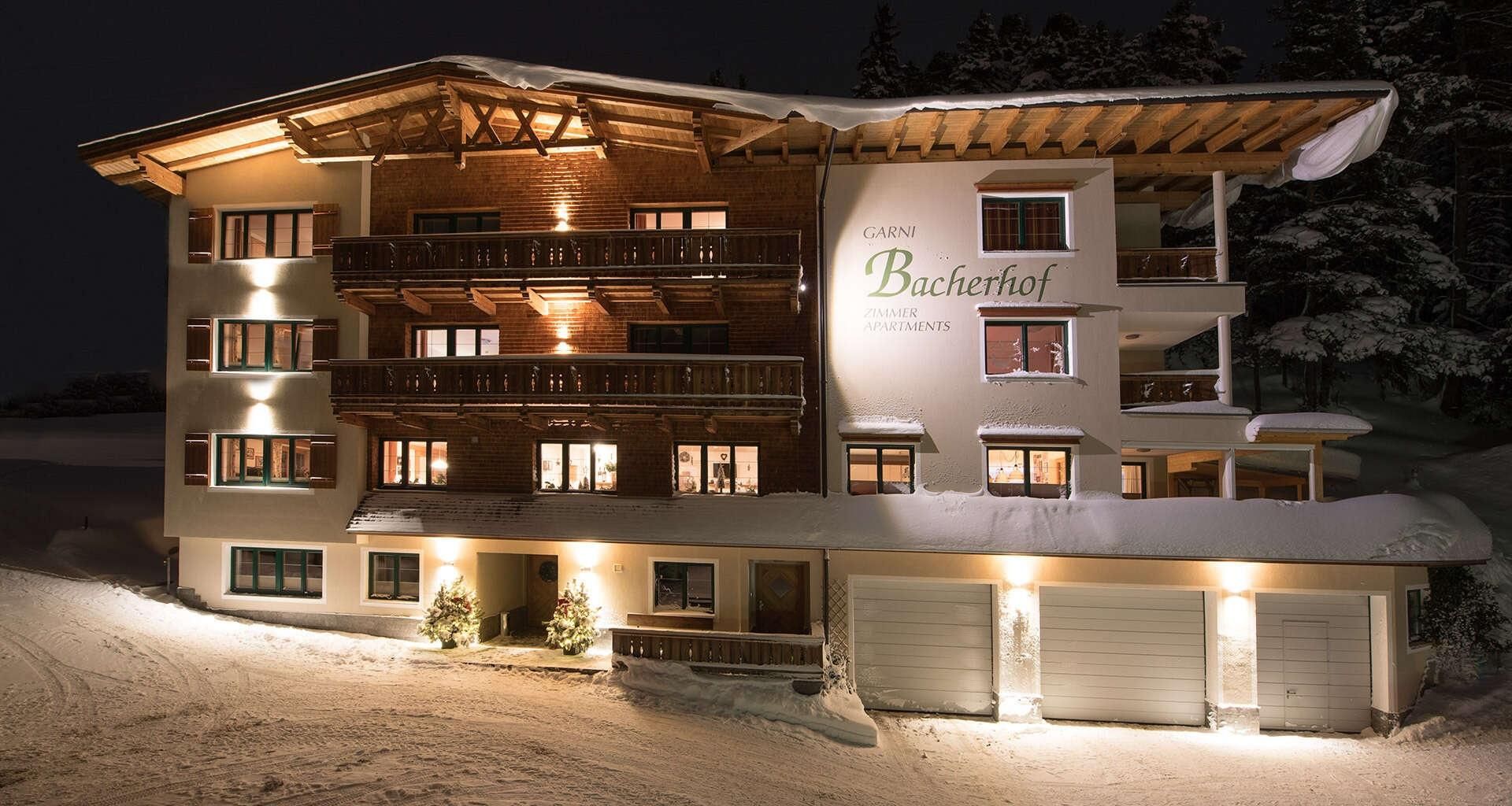 Hotel Garni Bacherhof in St Anton am Arlberg – Hausansicht im Winter in der Nacht